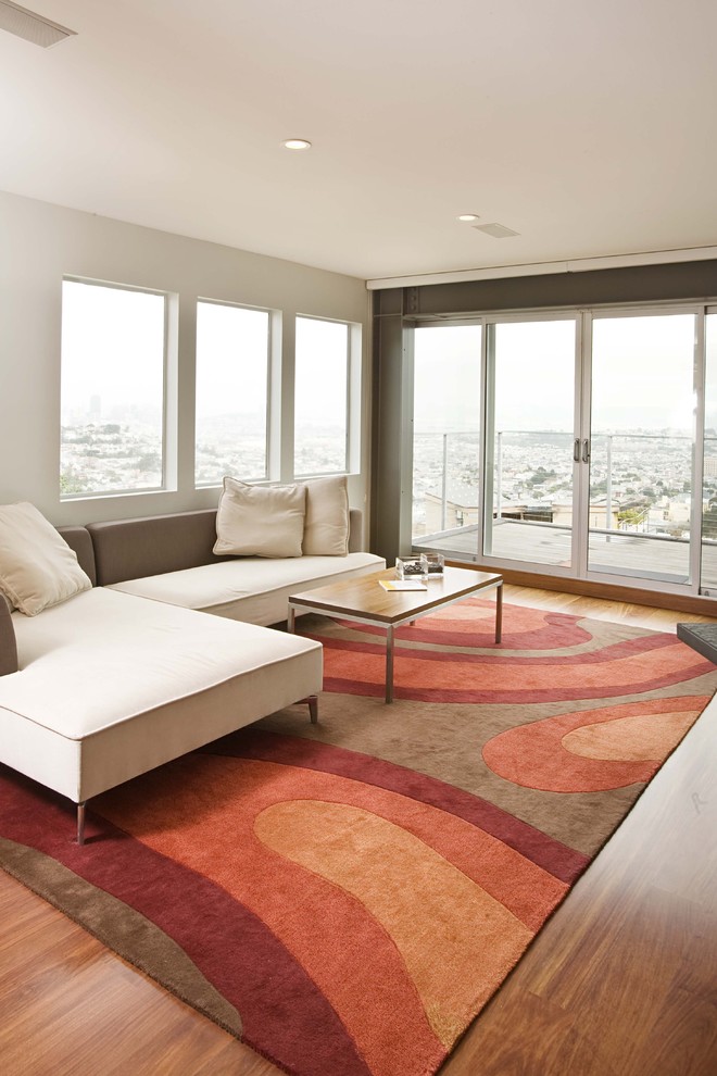 Example of a trendy medium tone wood floor family room design in San Francisco with white walls