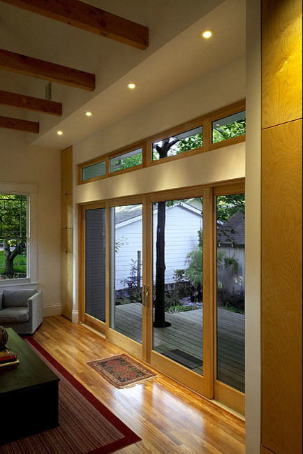 Cette photo montre une salle de séjour craftsman ouverte avec un mur blanc et un sol en bois brun.