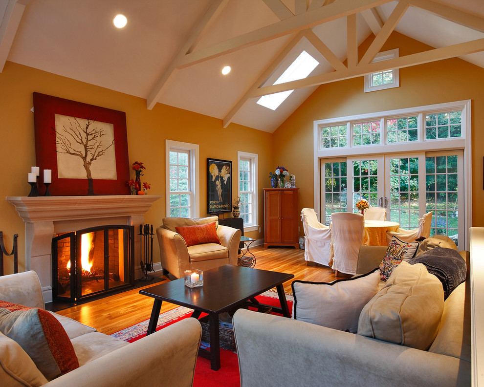 Family room - large transitional enclosed medium tone wood floor family room idea in Bridgeport with a standard fireplace, a stone fireplace and orange walls