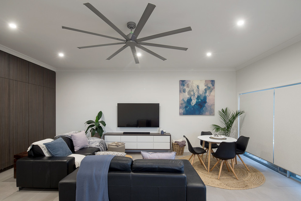 Imagen de sala de estar abierta moderna grande con paredes blancas, suelo de baldosas de cerámica y televisor colgado en la pared