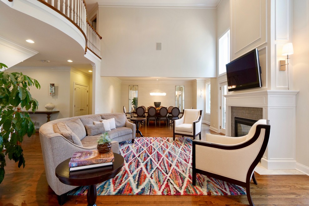Foto de sala de estar abierta tradicional renovada grande con suelo de madera en tonos medios, chimenea de doble cara, marco de chimenea de madera y televisor colgado en la pared