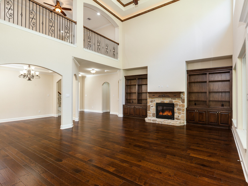 Family room - large contemporary family room idea in Houston with a standard fireplace and a stone fireplace