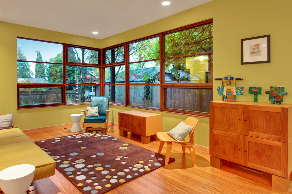 Imagen de sala de estar abierta actual con paredes verdes y suelo de madera en tonos medios