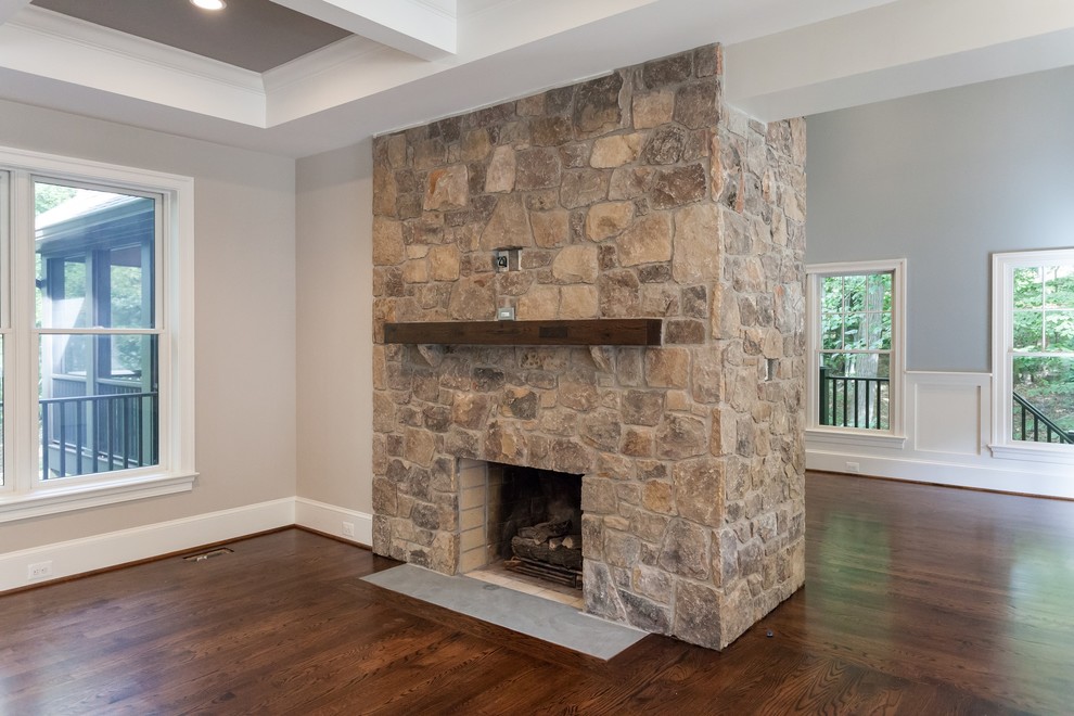 Inspiration for a classic open plan games room in DC Metro with grey walls, medium hardwood flooring, a standard fireplace, a stone fireplace surround and brown floors.