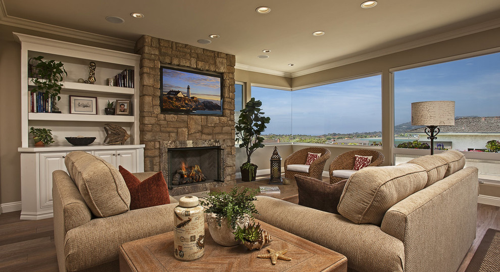 Family room - large coastal open concept medium tone wood floor family room idea in Orange County with beige walls, a standard fireplace, a stone fireplace and a media wall