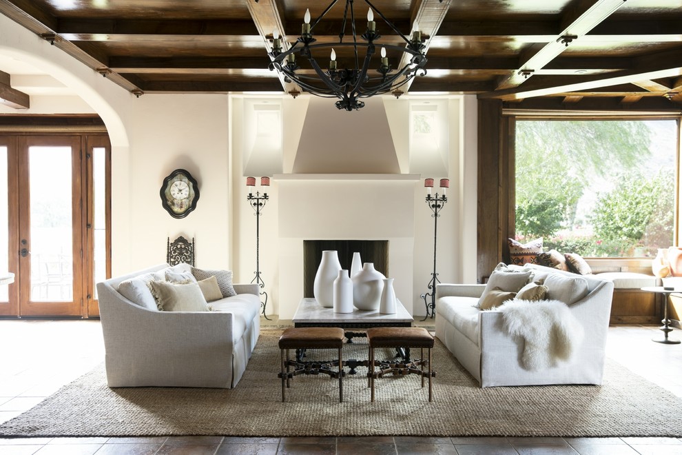 Источник вдохновения для домашнего уюта: открытая гостиная комната в стиле шебби-шик с белыми стенами, полом из керамической плитки, стандартным камином, фасадом камина из штукатурки и коричневым полом