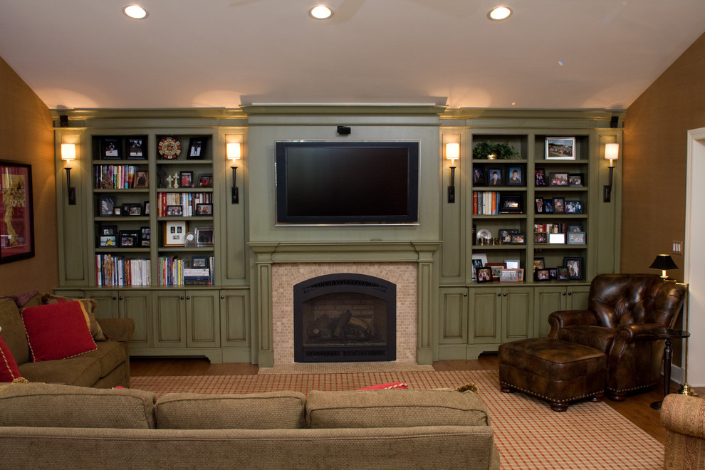На фото: изолированная гостиная комната среднего размера в классическом стиле с коричневыми стенами, паркетным полом среднего тона, стандартным камином, фасадом камина из кирпича и телевизором на стене с