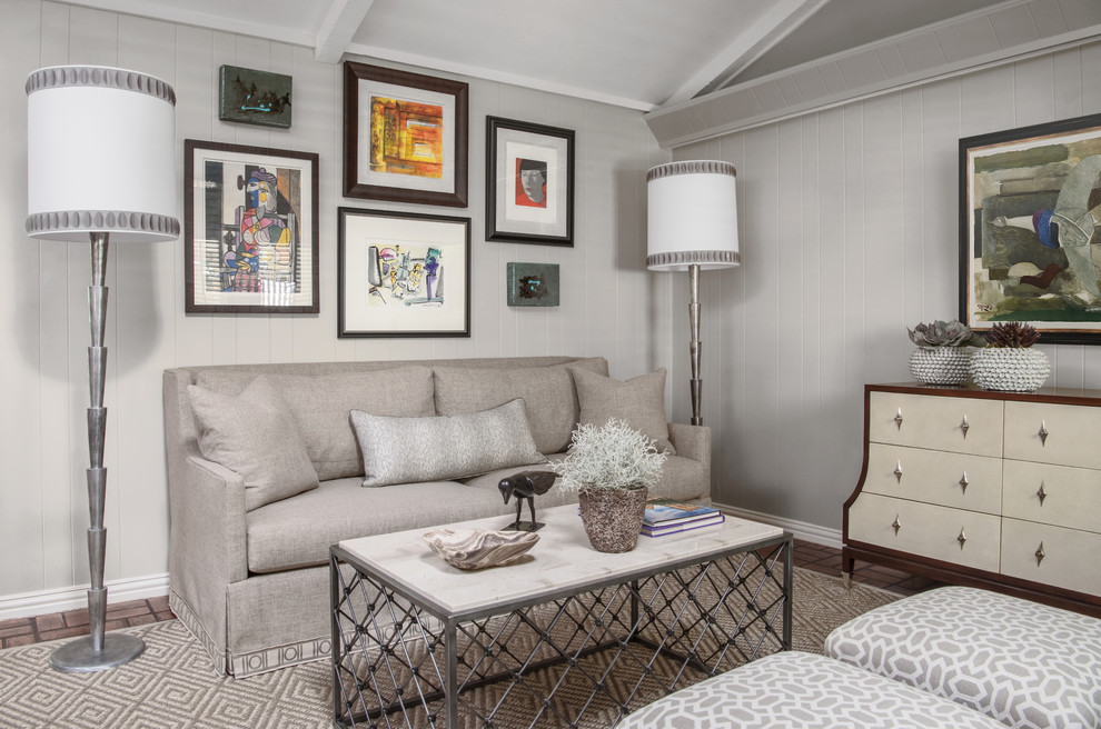 Идея дизайна: большая открытая гостиная комната в стиле неоклассика (современная классика) с серыми стенами, кирпичным полом, стандартным камином, фасадом камина из камня, скрытым телевизором и коричневым полом