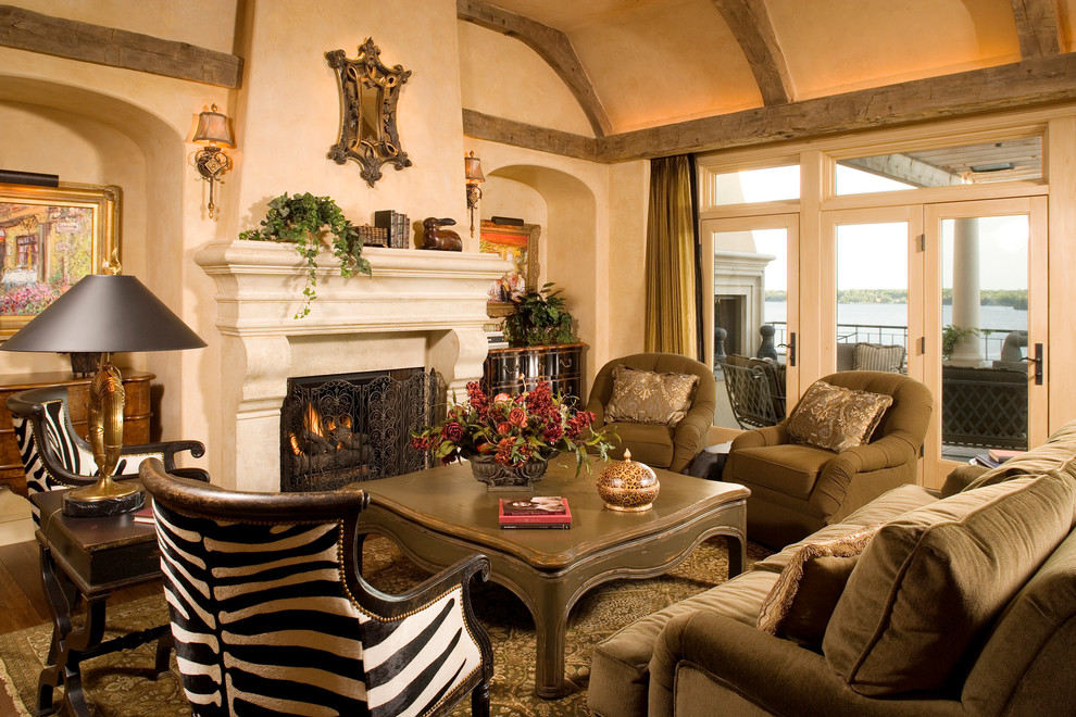 Foto de sala de estar abierta mediterránea de tamaño medio con paredes beige, suelo de madera oscura, todas las chimeneas y marco de chimenea de piedra