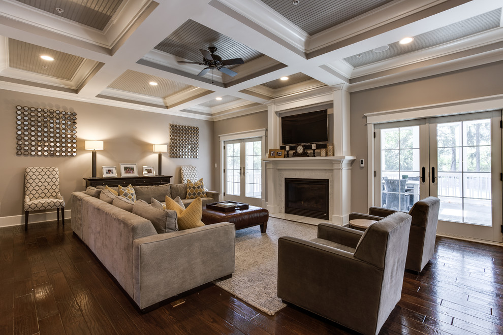 Diseño de sala de estar abierta clásica renovada grande con paredes beige, suelo de madera en tonos medios, todas las chimeneas, marco de chimenea de madera y televisor colgado en la pared
