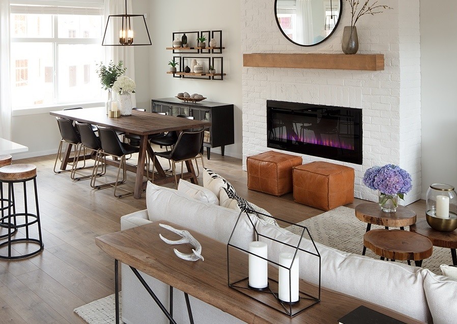 Inspiration for a small country open plan games room in Vancouver with white walls, laminate floors, a standard fireplace, a brick fireplace surround and a wall mounted tv.