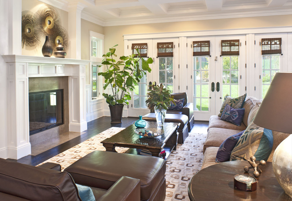 Elegant family room photo in Los Angeles with beige walls, a standard fireplace and no tv