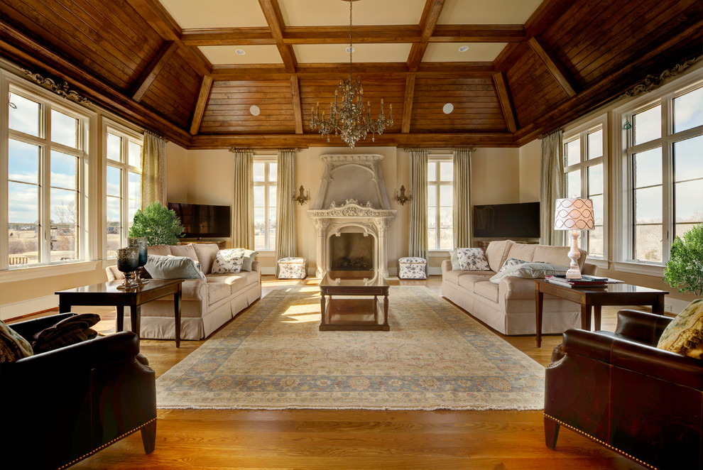 Großes, Offenes Klassisches Wohnzimmer mit beiger Wandfarbe, braunem Holzboden, Kamin, Kaminumrandung aus Stein, braunem Boden und Eck-TV