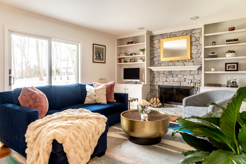 Abgetrenntes Klassisches Wohnzimmer mit weißer Wandfarbe, braunem Holzboden, Kamin, Kaminumrandung aus Stein, Multimediawand und braunem Boden in New York