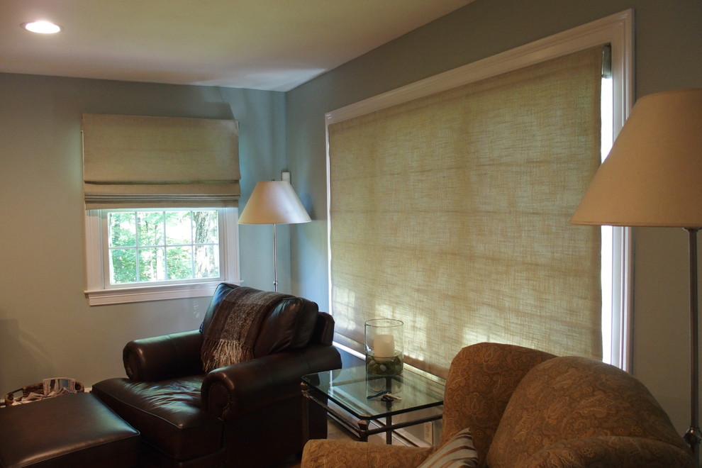 Пример оригинального дизайна: изолированная гостиная комната среднего размера в стиле неоклассика (современная классика) с серыми стенами, стандартным камином, фасадом камина из камня, телевизором на стене, светлым паркетным полом и коричневым полом