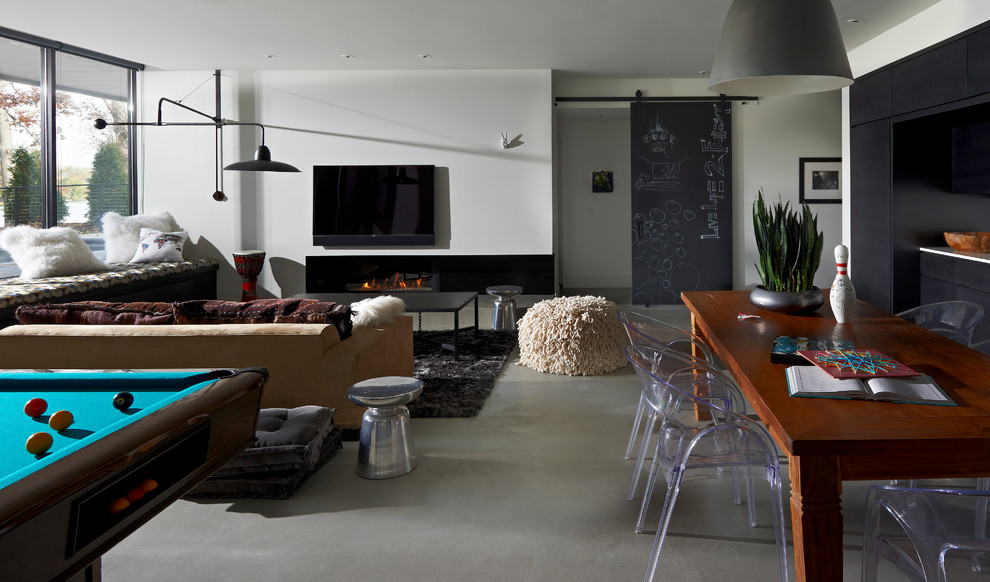 Cette image montre une salle de séjour design ouverte avec un mur blanc, une cheminée ribbon, un téléviseur fixé au mur et salle de jeu.