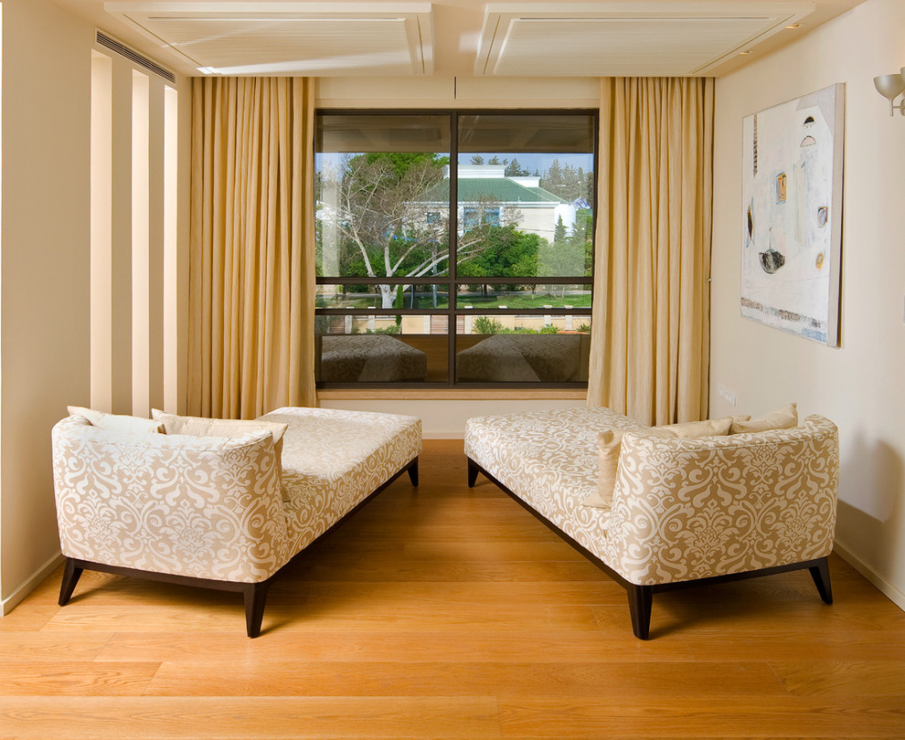 Modernes Wohnzimmer mit beiger Wandfarbe und braunem Holzboden in Sonstige