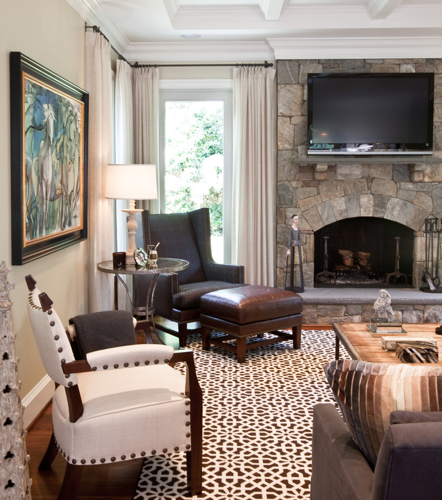 Klassisches Wohnzimmer mit beiger Wandfarbe, dunklem Holzboden, Kamin, Kaminumrandung aus Stein und TV-Wand in Washington, D.C.