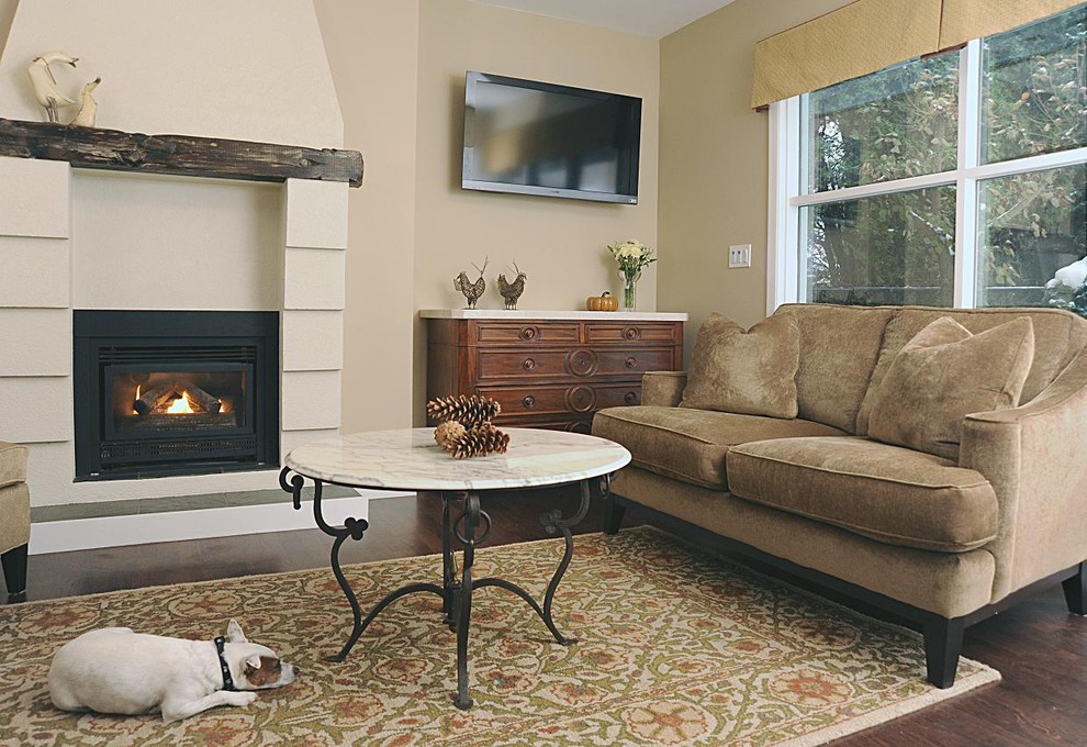 Example of a mid-sized classic dark wood floor family room design in Vancouver with beige walls, a standard fireplace and a wall-mounted tv