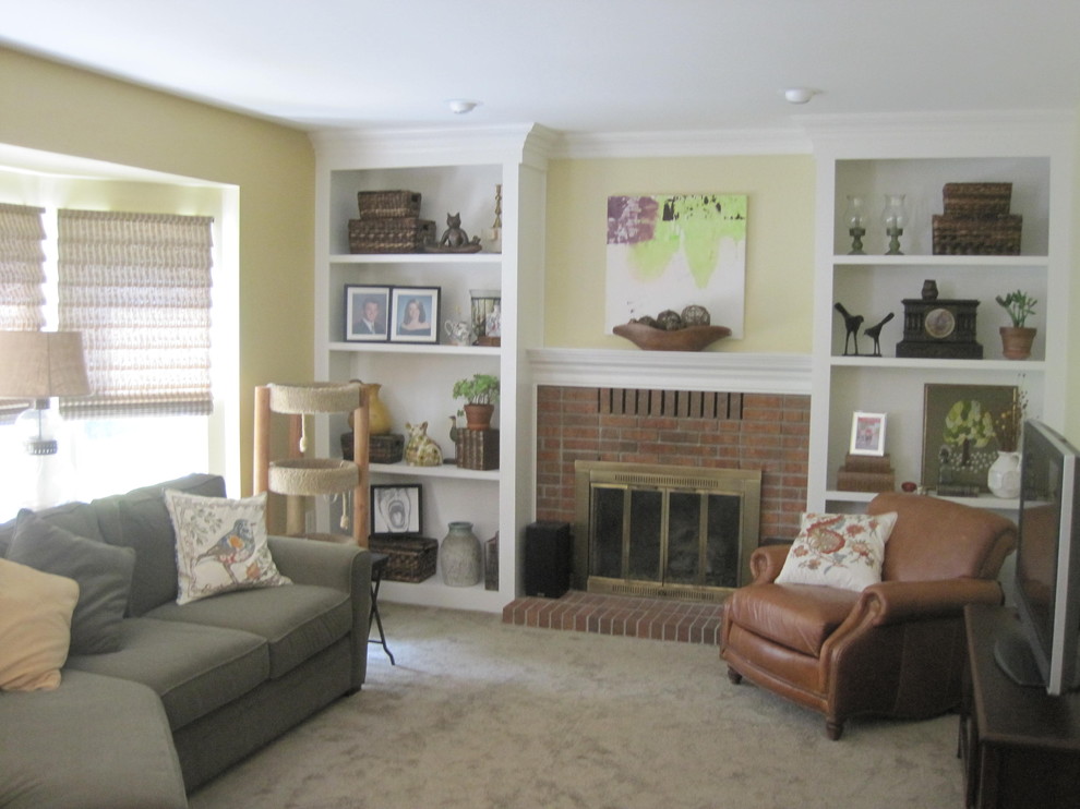 Réalisation d'une salle de séjour tradition de taille moyenne avec un mur jaune, moquette, une cheminée standard, un manteau de cheminée en brique et un téléviseur indépendant.