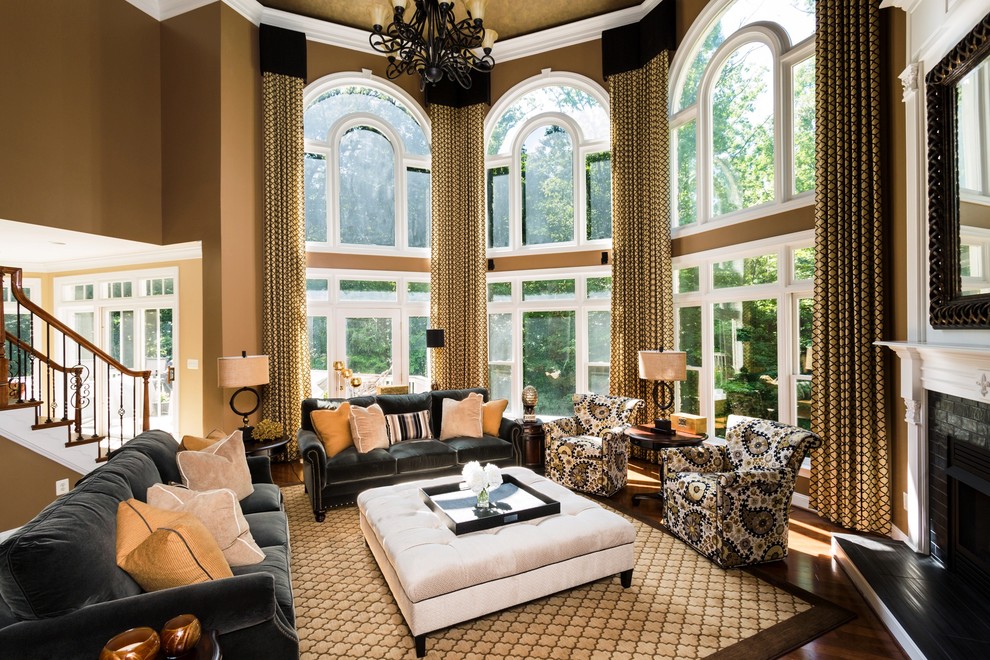 Imagen de sala de estar abierta tradicional renovada grande con paredes marrones, suelo de madera clara, chimeneas suspendidas, marco de chimenea de ladrillo y pared multimedia