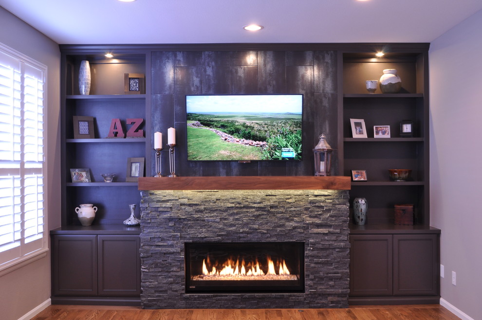 デンバーにある高級な小さなコンテンポラリースタイルのおしゃれなファミリールーム (グレーの壁、無垢フローリング、横長型暖炉、石材の暖炉まわり) の写真