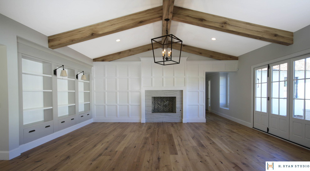 Ejemplo de sala de estar abierta clásica renovada con paredes blancas, suelo de madera en tonos medios, todas las chimeneas y marco de chimenea de piedra
