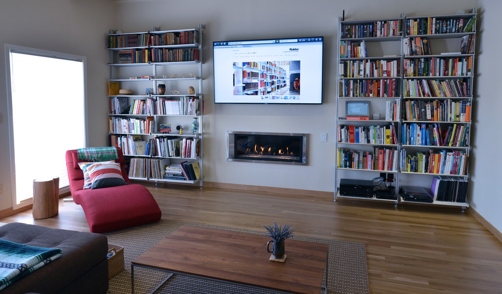 Стильный дизайн: большая открытая гостиная комната в стиле модернизм с с книжными шкафами и полками и телевизором на стене - последний тренд