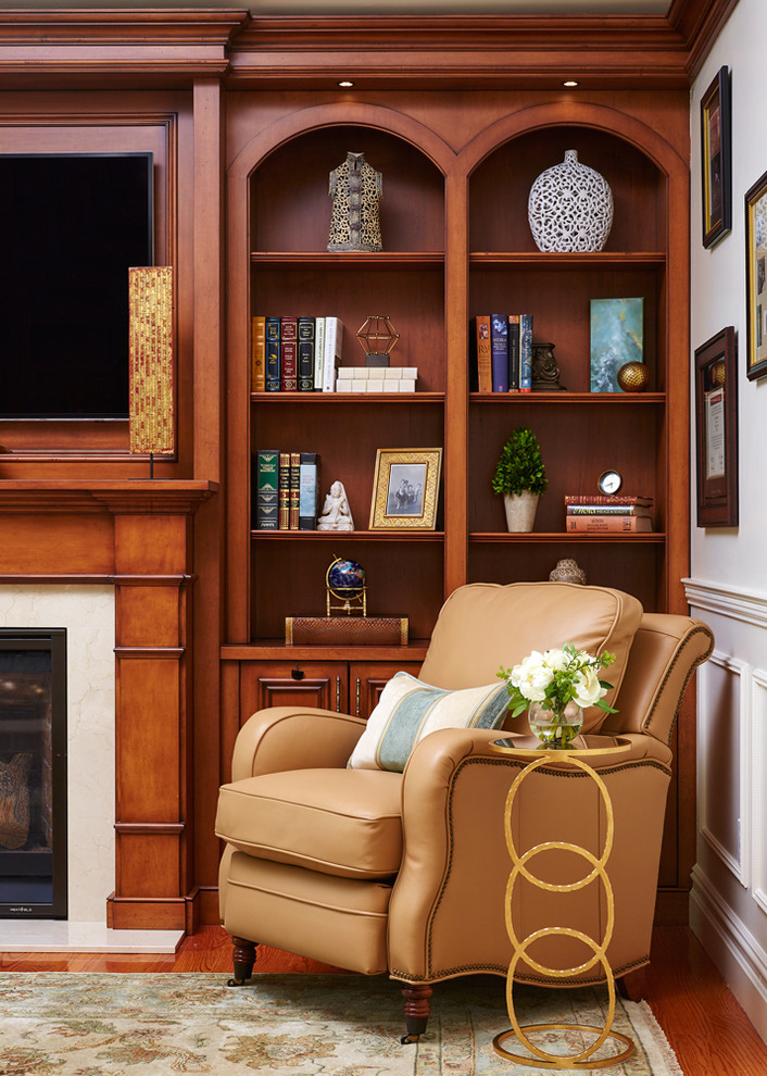 Imagen de sala de estar con biblioteca tradicional renovada de tamaño medio con todas las chimeneas, marco de chimenea de madera y pared multimedia