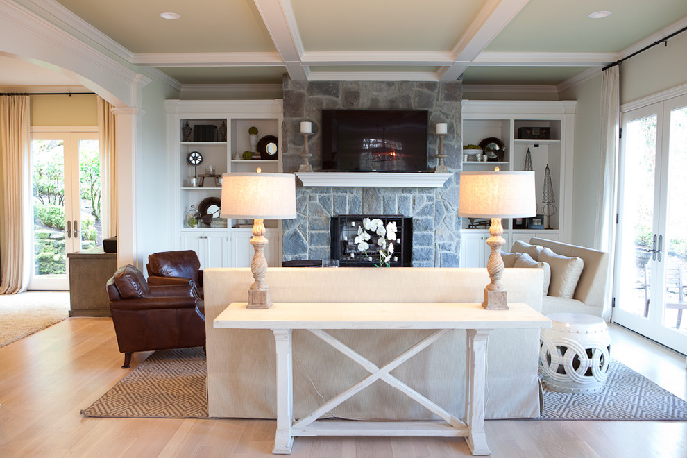 Elegant light wood floor family room photo in Portland with a standard fireplace, a stone fireplace and a wall-mounted tv