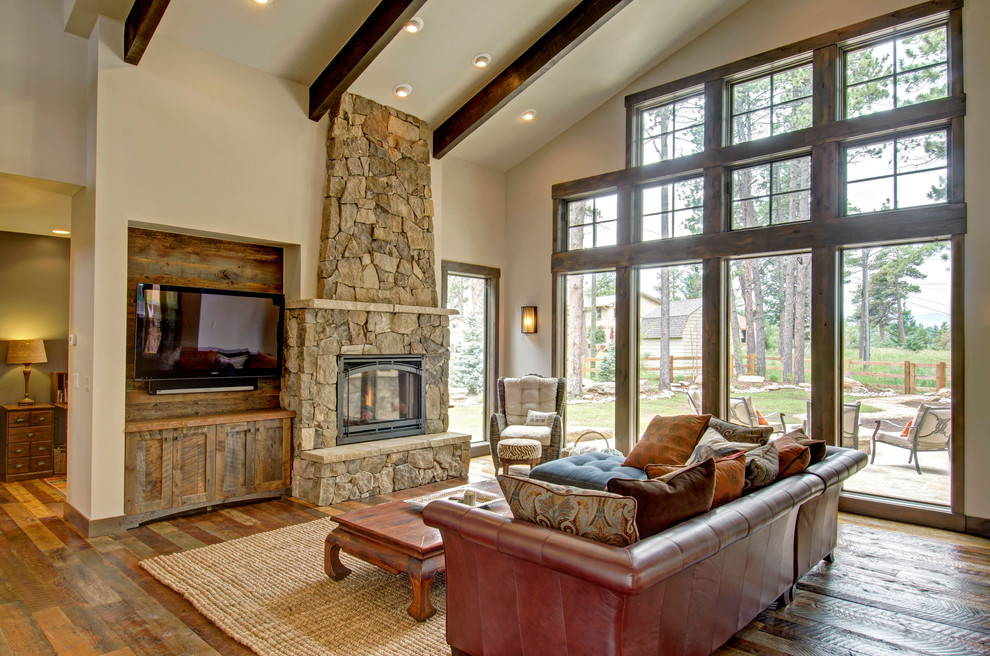 Family room - rustic dark wood floor family room idea in Denver with beige walls, a standard fireplace, a stone fireplace and a wall-mounted tv