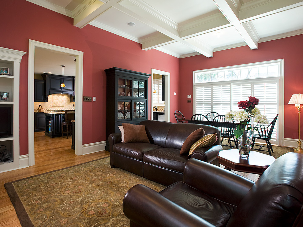 Aménagement d'une salle de séjour classique de taille moyenne et ouverte avec un mur rouge, un sol en bois brun, aucune cheminée et aucun téléviseur.