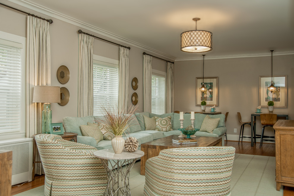 Immagine di un grande soggiorno design aperto con pareti beige e pavimento in legno massello medio