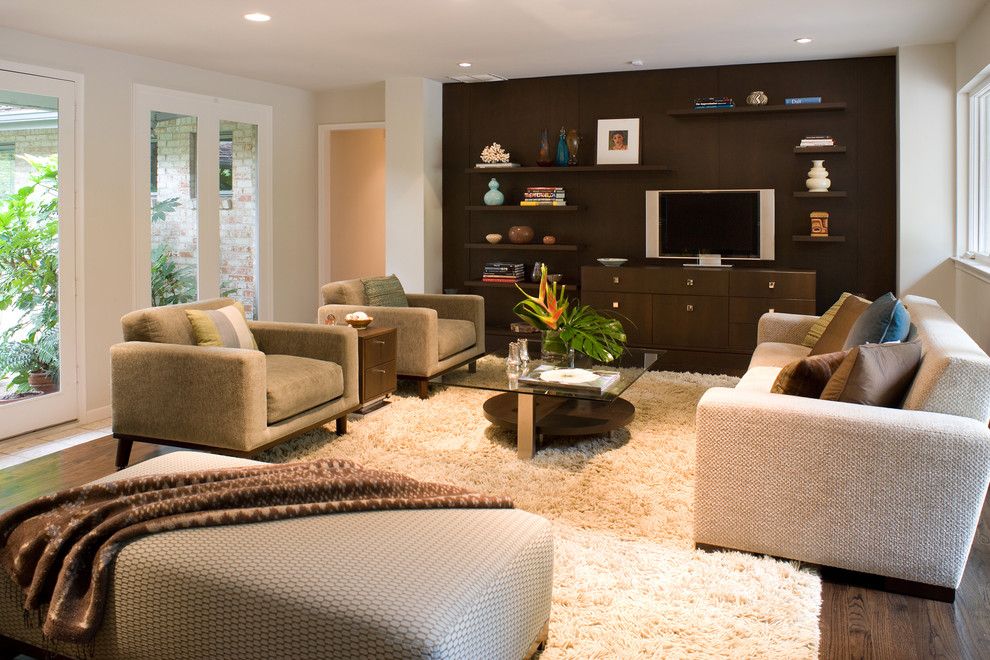 Example of a large trendy enclosed dark wood floor and brown floor family room design in New York with gray walls, no fireplace and a tv stand