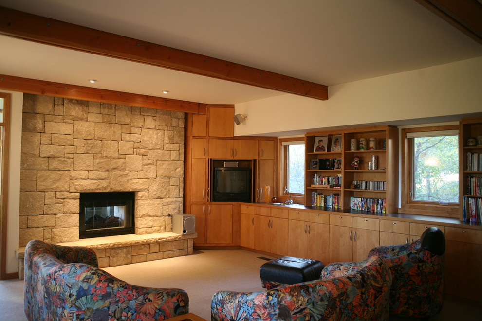 На фото: большая изолированная гостиная комната в современном стиле с белыми стенами, ковровым покрытием, двусторонним камином, фасадом камина из камня, телевизором в углу и бежевым полом