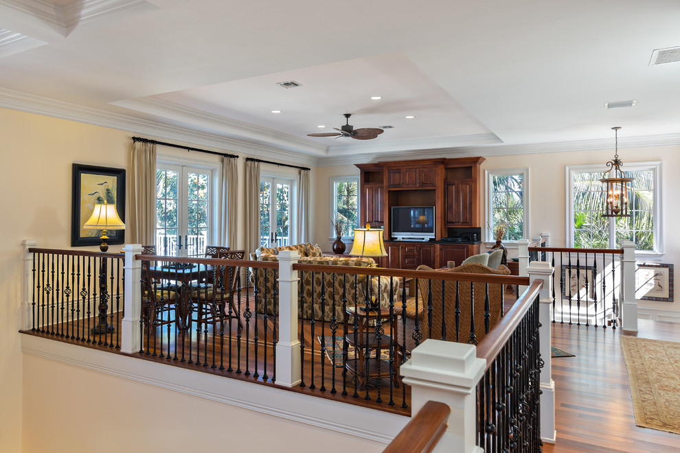 Klassisches Wohnzimmer ohne Kamin, im Loft-Stil mit beiger Wandfarbe, braunem Holzboden und Multimediawand in Miami