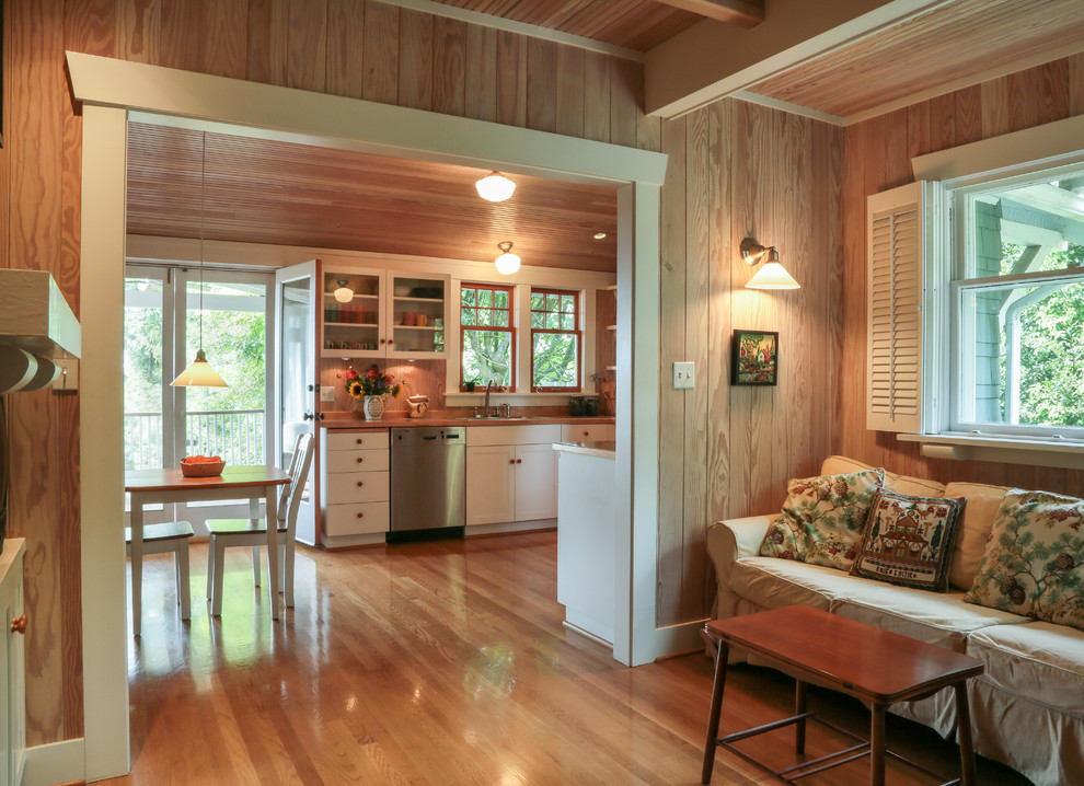 Imagen de sala de estar abierta clásica pequeña con suelo de madera en tonos medios