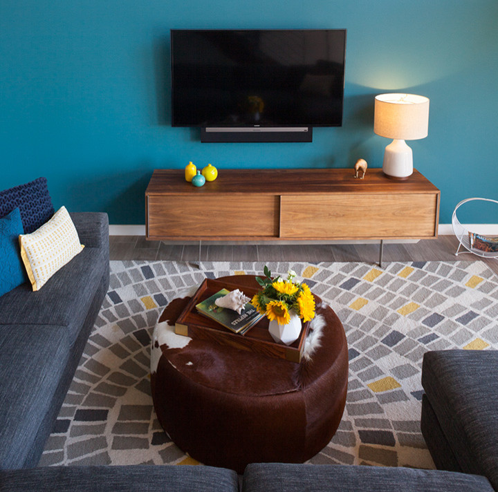 Cette photo montre une salle de séjour éclectique avec un mur bleu, un sol en carrelage de porcelaine et un téléviseur fixé au mur.
