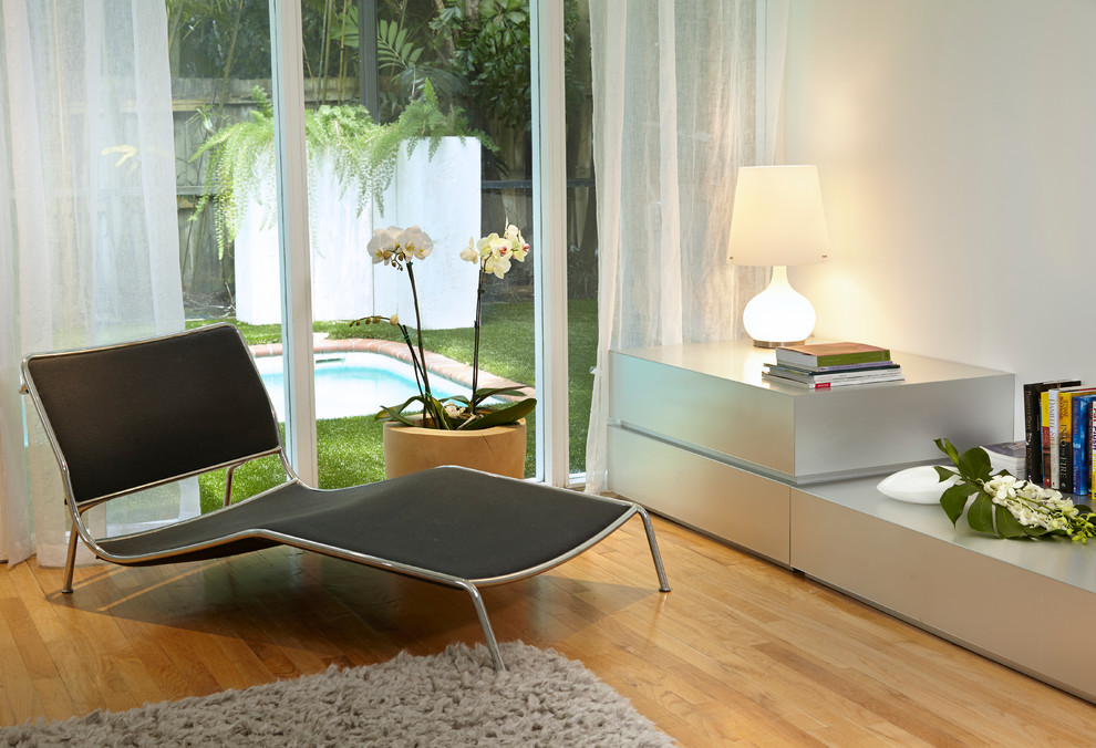 Mittelgroßes, Offenes Modernes Wohnzimmer ohne Kamin mit weißer Wandfarbe, hellem Holzboden und TV-Wand in Miami