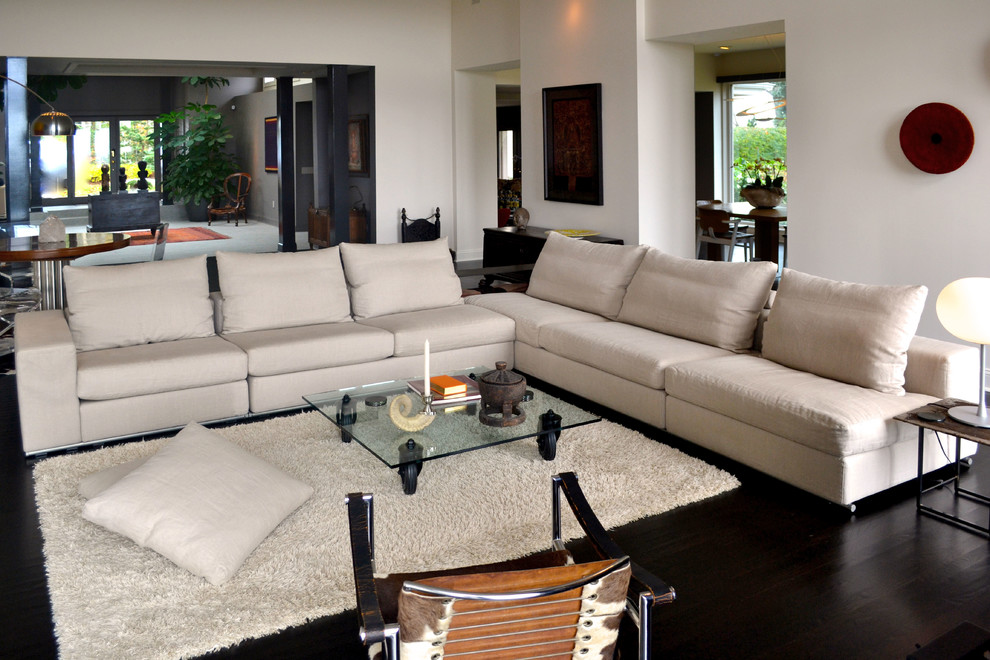Imagen de sala de estar abierta contemporánea grande con paredes blancas y suelo de madera oscura