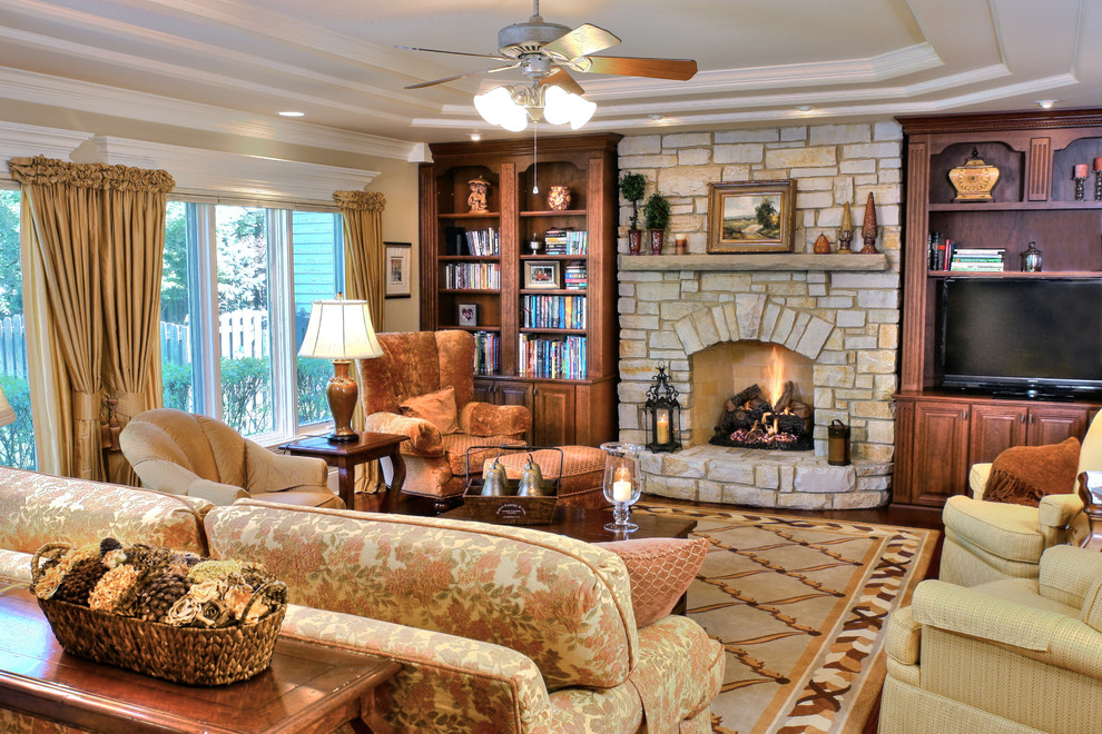 Ejemplo de sala de estar clásica grande con paredes beige, todas las chimeneas, marco de chimenea de piedra y pared multimedia