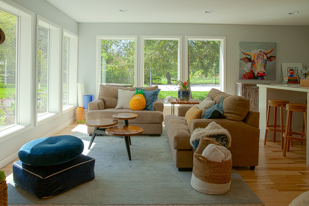 Foto di un grande soggiorno chic aperto con sala giochi, pareti grigie, parquet chiaro e TV autoportante