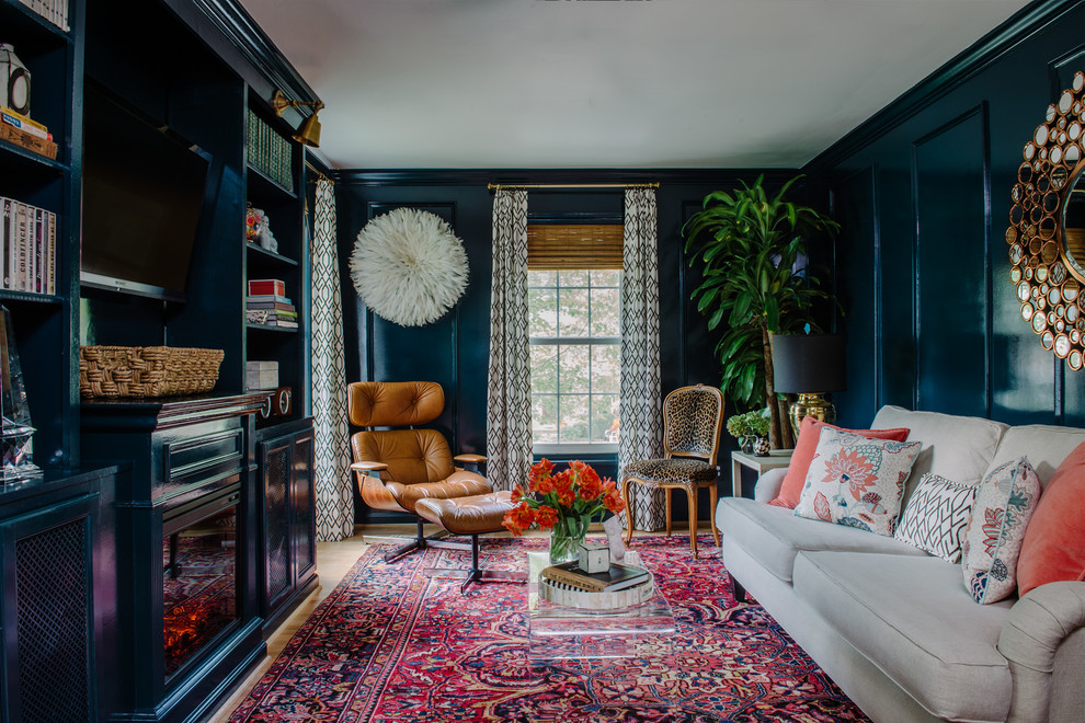 Imagen de sala de estar cerrada ecléctica pequeña con paredes azules, suelo de madera clara, todas las chimeneas, marco de chimenea de madera y televisor colgado en la pared