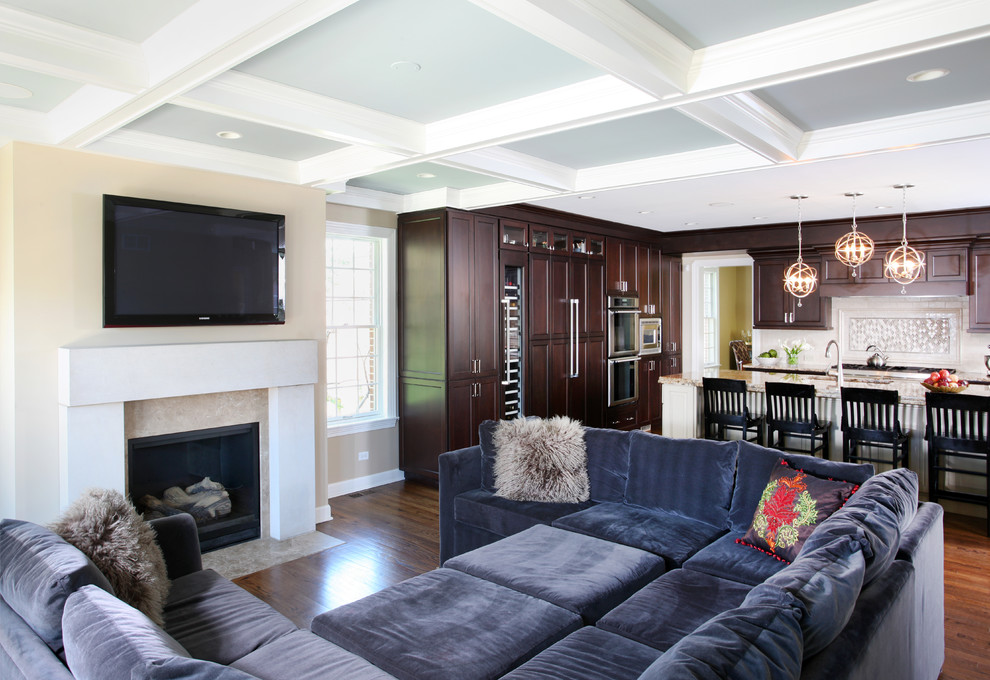 Offenes, Großes Klassisches Wohnzimmer mit beiger Wandfarbe, dunklem Holzboden, Kamin, TV-Wand und Kaminumrandung aus Stein in Chicago