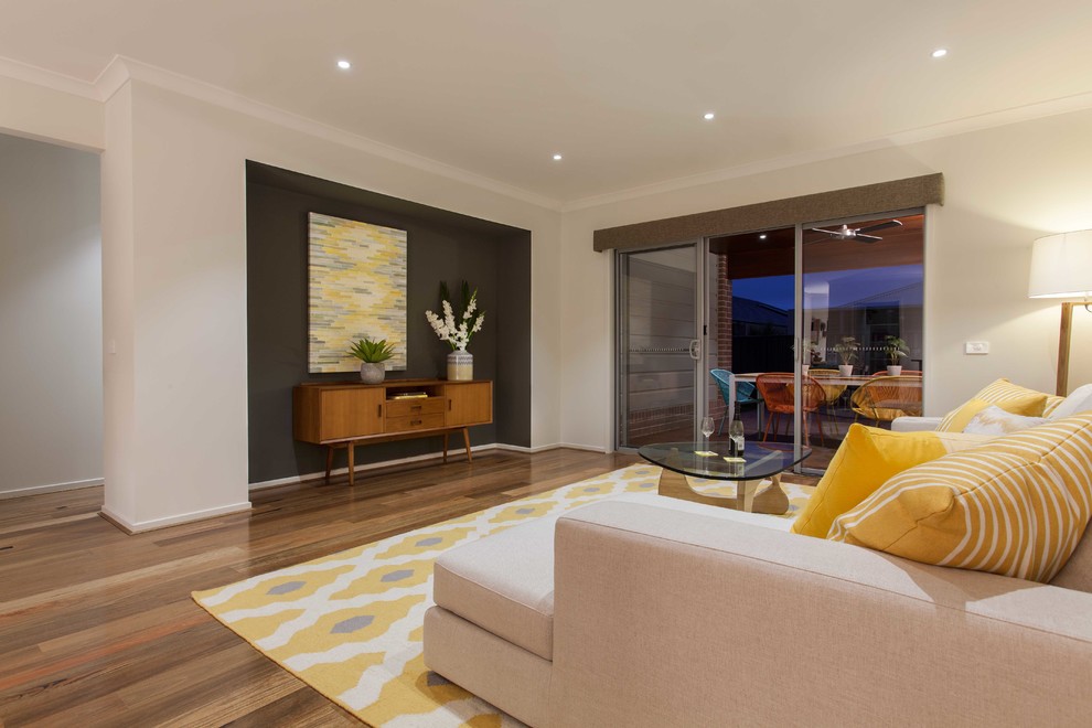Mittelgroßes, Offenes Modernes Wohnzimmer ohne Kamin mit weißer Wandfarbe, braunem Holzboden und TV-Wand in Melbourne