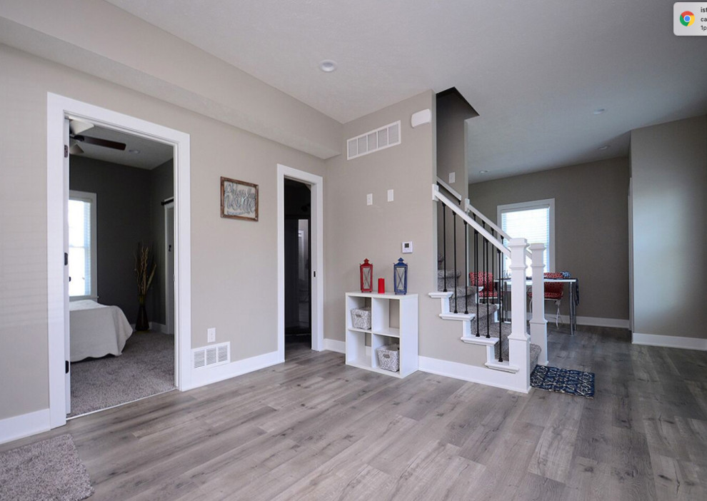 Modelo de sala de estar abierta minimalista pequeña sin chimenea y televisor con paredes grises, suelo vinílico y suelo gris