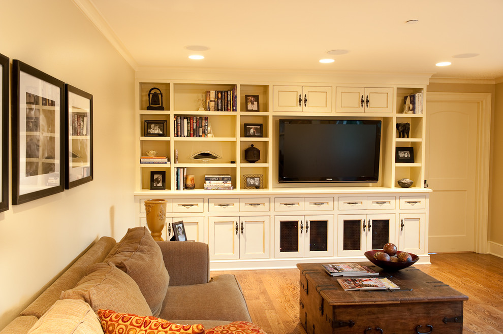 Diseño de sala de estar cerrada clásica de tamaño medio sin chimenea con suelo de madera clara, paredes beige y pared multimedia
