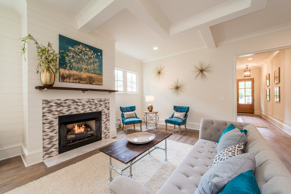 Large classic open plan games room in Charlotte with white walls, medium hardwood flooring, a standard fireplace, a tiled fireplace surround and brown floors.