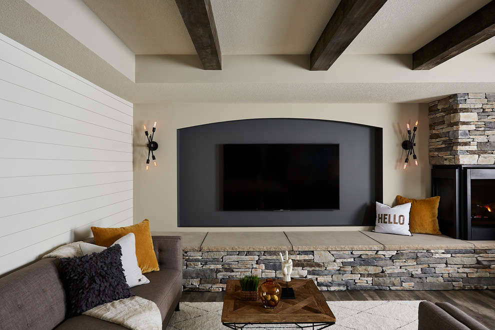 Пример оригинального дизайна: большая открытая гостиная комната в стиле неоклассика (современная классика) с серыми стенами, полом из винила, угловым камином, фасадом камина из камня, телевизором на стене и серым полом