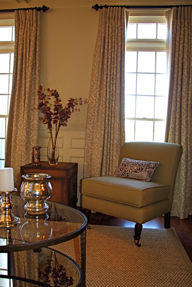 Cette image montre une petite salle de séjour traditionnelle fermée avec un mur beige et parquet foncé.